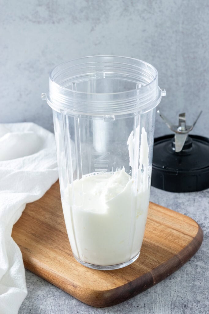 Milk and yogurt in a blender cup.