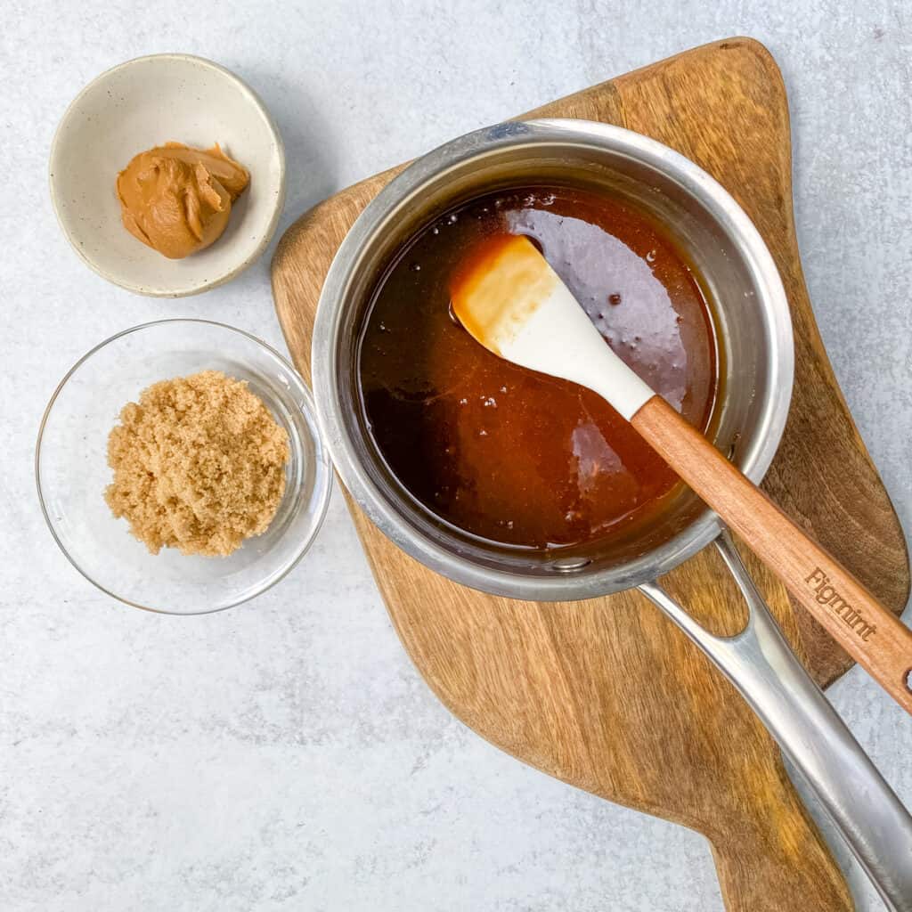 The cookie butter sauce is all stirred together in a saucepan, ready to add to cream.